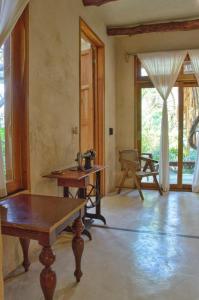 a living room with a table and some windows at La Casa de Mia Holbox in Holbox Island