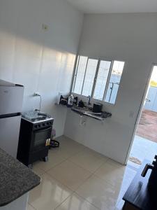a white kitchen with a stove and a sink at Casa próx senai e quartel in Três Lagoas