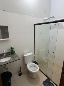 a bathroom with a toilet and a glass shower at Casa próx senai e quartel in Três Lagoas