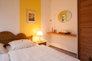 a bedroom with a bed and a lamp and a mirror at Gästehaus Luv und Lee in Schwartbuck +15 photos