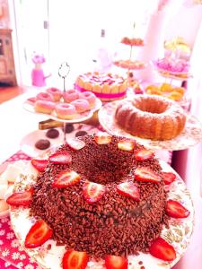 a table with a chocolate cake with strawberries on it at Pink Village Boutique in Campos do Jordão +118 photos