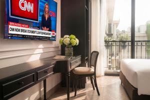 a bedroom with a desk and a tv on a wall at Euphoria Hotel & Spa in Hanoi