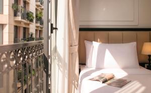 a bed on a balcony with a book on it at Euphoria Hotel & Spa in Hanoi +38 photos