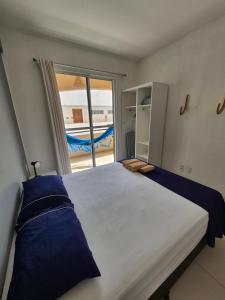 a bedroom with a large bed with a large window at Cumbuco Residence #203 in Caucaia +5 photos