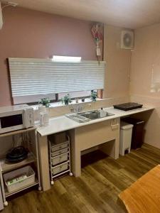 a kitchen with a sink and a counter with a microwave at Folk-ish Style 風 in Miyazu +23 photos