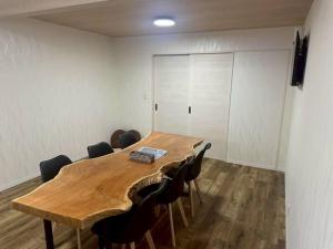 a conference room with a wooden table and chairs at Folk-ish Style 風 in Miyazu
