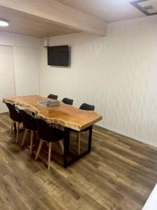 a conference room with a wooden table and chairs at Folk-ish Style 風 in Miyazu