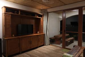 a living room with a television on a wooden entertainment center at An Hải Beachfront Retreat Ninh Thuận in Thôn Dư Khánh