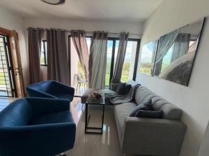 a living room with a couch and two blue chairs at Torre con ascensor y vigilancia in Santiago de los Caballeros