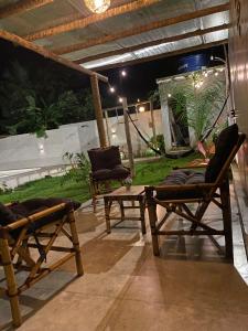 two chairs and a table on a patio at night at Rancho de férias in Japaratinga