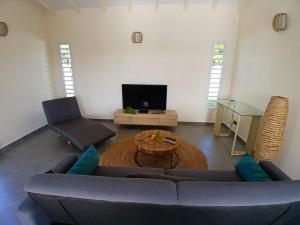 a living room with a couch and a table at Sun House in Grand-Bourg