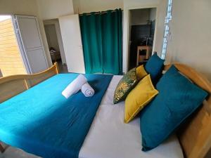a bed with blue sheets and pillows on it at Sun House in Grand-Bourg +10 photos