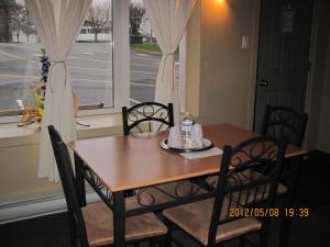 a dining room table and chairs and a window at Motel Parc Beaumont Inc. in Beaumont
