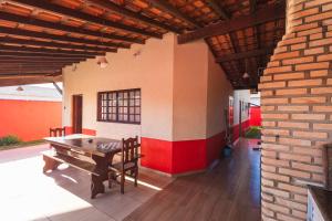 a patio with a table and a brick wall at Sinuca, churrasqueira e fogueira a 300 metros do mar in Itanhaém