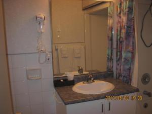 a bathroom with a sink and a mirror at Motel Parc Beaumont Inc. in Beaumont