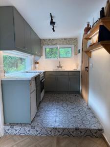 a kitchen with gray cabinets and a white refrigerator at A Lómbre in Ḩarīq al Kufūr