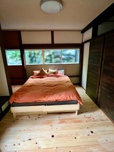 a bedroom with a large bed in a room with windows at NouHarborVilla in Itoigawa