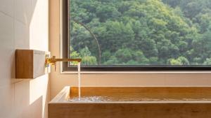 a bathroom with a bathtub with water coming out of a window at Hongcheon Around River Poolvilla Pension in Mangdani