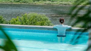 a man is standing in a swimming pool at Hongcheon Around River Poolvilla Pension in Mangdani