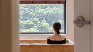 a woman sitting in front of a window at Hongcheon Around River Poolvilla Pension in Mangdani +1 photo