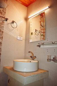 a bathroom with a sink and a mirror at Samoon Guest House Sonmarg in Kulan