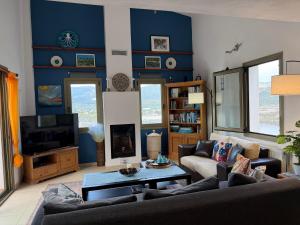 a living room with a blue accent wall at Skiathos Seaview Villa with Pool in Punta
