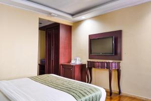 a hotel room with a bed and a flat screen tv at SNUZ Hotel Menteng in Jakarta