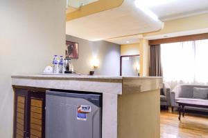 a kitchen with a counter top and a living room at SNUZ Hotel Menteng in Jakarta