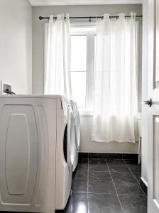 a white laundry room with a washer and a window at NEW Spacious BR with Ensuite Bathroom in Innisfil