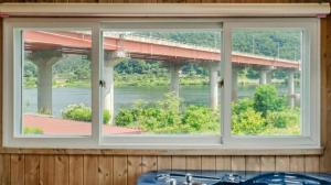 a window with a view of a bridge over a river at Chuncheon Remember Pet Pension in Chuncheon +2 photos