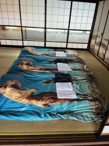 a bed in a room with a blanket on the floor at 悠の宿 in Katsuyama