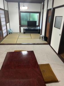 a living room with a table and a tv at 悠の宿 in Katsuyama