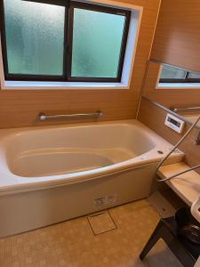 a bath tub in a bathroom with a window at 悠の宿 in Katsuyama +9 photos