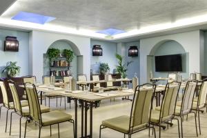 a conference room with tables and chairs and a flat screen tv at Grand Hotel Savoia Genova, Curio Collection by Hilton in Genoa
