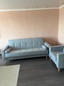 a blue couch sitting in a living room at Квартира ЛЮКС in Balqash