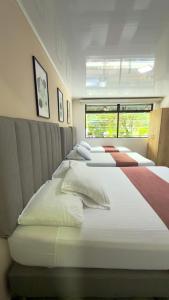 a group of four beds in a room at Hotel Nakama in Medellín