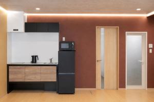 a kitchen with a refrigerator and a microwave at 富士見莊sl0582 in Oshino