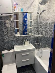 a bathroom with a sink and a shower and a tub at Квартира ЛЮКС in Balqash