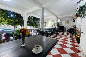 a table with a cup of coffee and flowers on a porch at Twins Kobuleti in Kobuleti