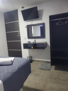 a bedroom with a bed and a tv on the wall at Lacosta Josss in Acapulco