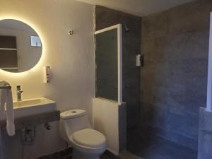 a bathroom with a toilet and a sink and a shower at Lacosta Josss in Acapulco