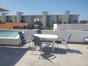 a table and chairs on the roof of a building at Lacosta Josss in Acapulco