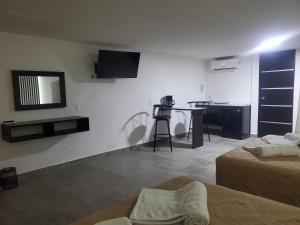a room with two beds and a table with a mirror at Lacosta Josss in Acapulco +10 photos