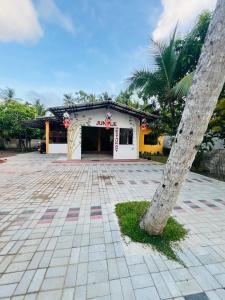 a building with a palm tree in front of it at Jungle Restaurant and Villa in Unawatuna