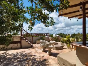 a white toilet sitting on a patio under a tree at La Casa de Mia Holbox in Holbox Island
