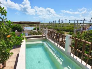 a swimming pool in a garden with a fence at La Casa de Mia Holbox in Holbox Island