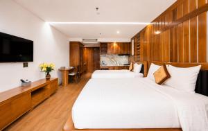 a hotel room with two beds and a television at Mixay Boutique Hotel Da Nang in Danang