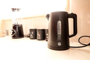a black appliance sitting on top of a kitchen counter at Elite Garden Cabin, Cozy Hideaway in Welkom with Fast WiFi, Free Parking in Welkom
