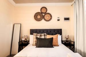 a bedroom with a bed with two plates on the wall at Elite Garden Cabin, Cozy Hideaway in Welkom with Fast WiFi, Free Parking in Welkom