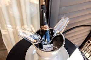 a can of wine and two glasses on a table at Elite Garden Cabin, Cozy Hideaway in Welkom with Fast WiFi, Free Parking in Welkom